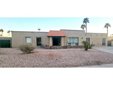 Charming brick home with a red tile roof and low-maintenance desert landscaping at 6511 E Sharon Dr, Scottsdale, AZ 85254