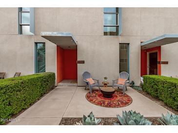 Inviting front patio with seating area, decorative rug, and stylish modern architecture at 7047 E Earll Dr # 1002, Scottsdale, AZ 85251