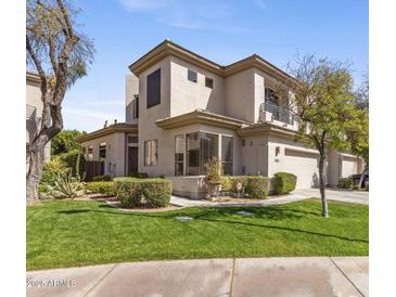 Contemporary two-story home with a well-manicured lawn and lush landscaping at 7282 E Del Acero Dr, Scottsdale, AZ 85258