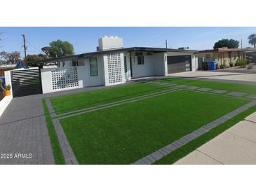 Modern home boasting sleek lines, a well-manicured lawn, and a contemporary driveway design at 8833 N 39Th Ave, Phoenix, AZ 85051