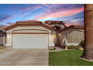 Inviting single-story home with a two-car garage, desert landscaping, and a tile roof at 15240 W Melissa Ln, Surprise, AZ 85374