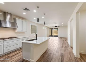 A modern kitchen featuring a large island with a white countertop and stainless steel appliances at 2113 N 210Th Ave, Buckeye, AZ 85396