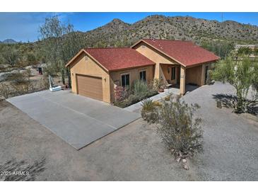 Inviting single-story home with a spacious driveway, two-car garage, and mountain views at 30066 N Holly Dr, San Tan Valley, AZ 85144