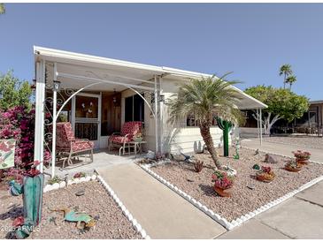 Charming single-story home with a well-manicured yard and cozy covered porch at 661 N Hawes Rd # 34, Mesa, AZ 85208