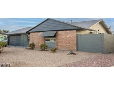 Charming single-story brick home with a well-maintained front yard and gray accents at 10018 N 103Rd Ave, Sun City, AZ 85351