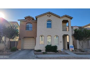 A charming two-story stucco home with a well-manicured front yard and inviting curb appeal at 10039 W Kingman St, Tolleson, AZ 85353