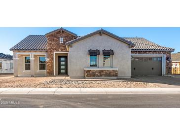 Beautiful single-story home featuring stone accents, neutral stucco, and a two-car garage at 18742 N 269Th Ln, Buckeye, AZ 85396