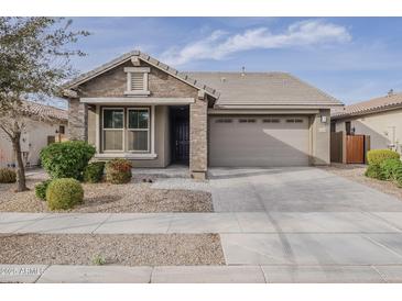 Charming single-story home with stone accents, a well-manicured lawn, and a two-car garage at 22644 E Quintero Ct, Queen Creek, AZ 85142