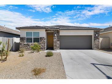 Charming single-story home with stone accents, desert landscaping, and a two-car garage at 24220 W Ripple Rd, Buckeye, AZ 85326