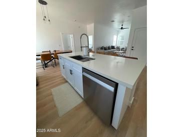 Bright kitchen features an island with a sink and stainless steel dishwasher at 2444 W Morten Ave, Phoenix, AZ 85021