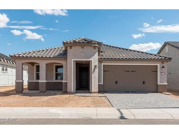 Charming single-story home with a two-car garage and a well-manicured lawn at 26957 W Lone Cactus Dr, Buckeye, AZ 85396