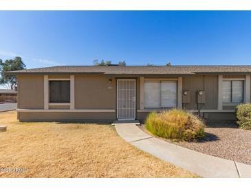 Charming single-story home featuring a secure screen door and a well-maintained front yard at 6711 W Osborn Rd # 127, Phoenix, AZ 85033