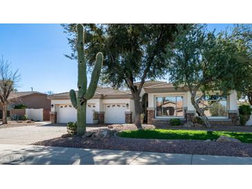 Charming home featuring a well-manicured lawn, mature trees, and a three-car garage at 737 E Boston St, Gilbert, AZ 85295