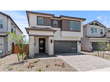 Beautiful two-story home with a modern design, dark gray garage door, and inviting stone-accented entrance at 7987 W Griswold Rd, Peoria, AZ 85345