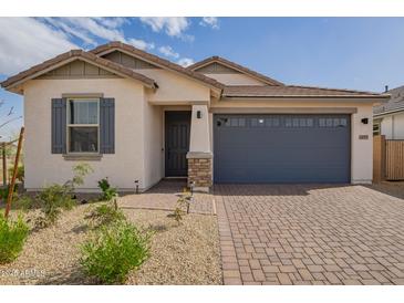 Charming single-story home with a two car garage, paver driveway, and low maintenance desert landscaping at 14377 W Alameda Rd, Surprise, AZ 85387