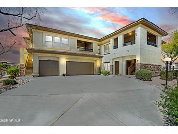 Two-story beige stucco home featuring dual garages and private balconies, set against a colorful twilight sky at 16800 E El Lago Blvd # 2072, Fountain Hills, AZ 85268