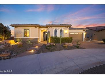 Charming home showcasing desert landscaping, a stone walkway, and a two-car garage at 19051 N 259Th Ave, Buckeye, AZ 85396