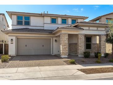 Inviting two-story home featuring a large two-car garage and a stylish stone-accented entrance at 20979 E Mayberry Rd, Queen Creek, AZ 85142