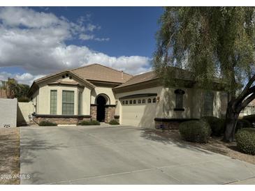 Charming single-story home boasts neutral stucco, tiled roof, stone accents, and an arched entry for inviting curb appeal at 3080 E Palmdale Ln, Gilbert, AZ 85298