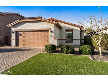 Charming single-story home featuring a two-car garage and beautiful landscaping with lush green grass at 398 W Honey Locust Ave, San Tan Valley, AZ 85140