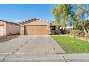 Charming single-story home featuring a well-manicured lawn and a convenient two-car garage and low maintenance landscaping at 1030 E Desert Moon Trl, San Tan Valley, AZ 85143