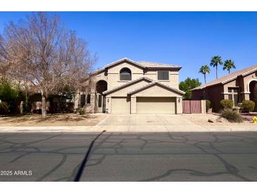 Charming two-story home featuring a spacious driveway, desert landscaping, and a classic Southwest design at 10452 E Florian Ave, Mesa, AZ 85208