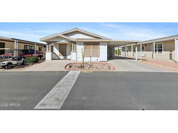 Charming single-story home featuring a well-manicured front yard and covered parking at 11596 W Sierra Dawn Blvd # 99, Surprise, AZ 85378