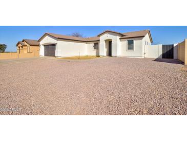 Charming single-story home features a neutral color palette and a well-maintained desert landscape at 12722 W Diaz Dr, Arizona City, AZ 85123