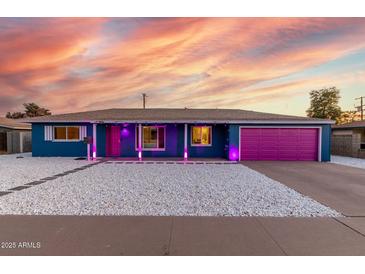 Charming single-story home featuring unique gravel landscaping and colorful pink garage door at 1435 W 6Th St, Mesa, AZ 85201