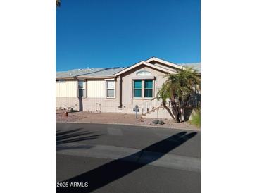 Tan and cream house with blue accent window, palm tree and walkway at 17200 W Bell Rd # 2301, Surprise, AZ 85374