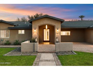 Charming single-story home boasts a welcoming entrance with meticulous landscaping and a charming brick pathway at 1801 E Berridge Ln, Phoenix, AZ 85016