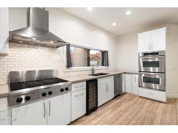 Modern kitchen with stainless steel appliances, white cabinets, and sleek countertops at 1801 E Berridge Ln, Phoenix, AZ 85016