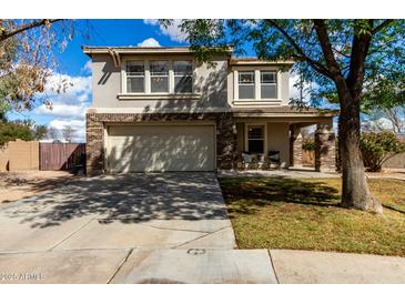 Charming two-story home featuring a two-car garage and a welcoming covered porch with seating area at 2562 E Oxford Ct, Gilbert, AZ 85295