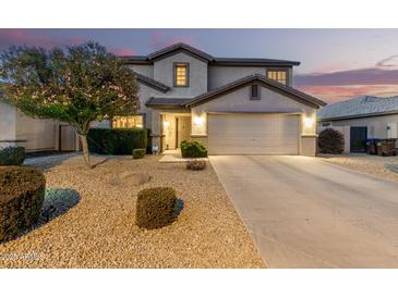 Charming two-story home showcasing a well-manicured front yard, desert landscaping, and an attached two-car garage at 2708 E Desert Rose Trl, San Tan Valley, AZ 85143