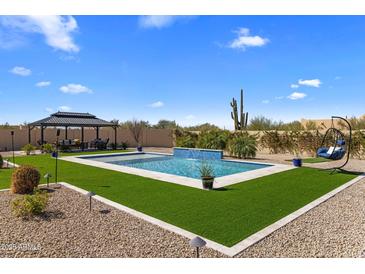 Backyard features a gorgeous pool with waterfall feature, desert landscaping, cabana and hanging swing at 30416 N 64Th Street --, Cave Creek, AZ 85331