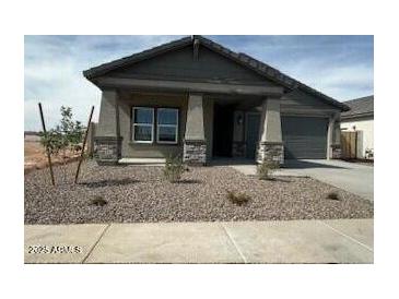 Charming single-story home with neutral stucco, rock landscaping, and attached two-car garage at 36972 W Santa Maria St, Maricopa, AZ 85138