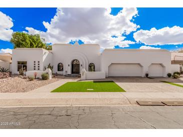 Stunning white home featuring a unique facade, arched entry, manicured desert landscaping and a two-car garage at 5345 E Mclellan Rd # 107, Mesa, AZ 85205