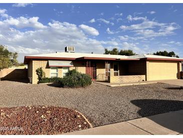 Charming single-story home with a brick facade, low-maintenance landscaping, and a two-car garage at 635 N 67Th Pl, Mesa, AZ 85205