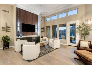 Elegant living room with a built-in bar, sleek wood accents, and bright natural light at 6576 E Whispering Mesquite Trl, Scottsdale, AZ 85266