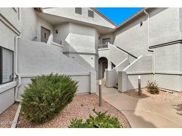 View of the condo building featuring well-maintained landscaping and neutral color palette at 9455 E Raintree Dr # 2020, Scottsdale, AZ 85260