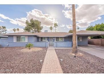 Charming single-story home with blue painted brick and a well-manicured, desert landscaped front yard at 10844 N 37Th St, Phoenix, AZ 85028