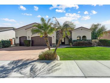 Charming single-story home featuring a well-manicured lawn, desert landscaping, and a three-car garage at 11141 E North Ln, Scottsdale, AZ 85259