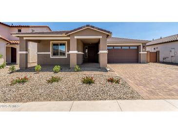 Charming single-story home with desert landscaping, brick driveway, and a two-car garage at 40563 W Michaels Dr, Maricopa, AZ 85138