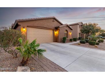 Charming house with two-car garage, a well-maintained lawn and desert landscaping around the house at 631 W Stanley Ave, San Tan Valley, AZ 85140