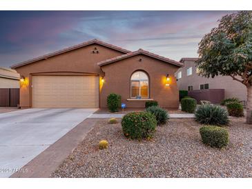 Charming single-story home with a two-car garage, desert landscaping, and a warm, inviting facade at 631 W Stanley Ave, San Tan Valley, AZ 85140