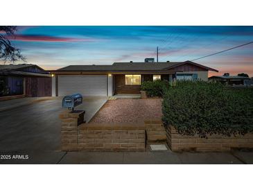 Charming single-story home featuring a well-manicured front yard and a two-car garage at 7102 W Wilshire Dr, Phoenix, AZ 85035