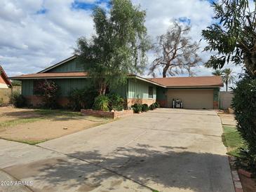 Charming single-story home featuring a spacious driveway and well-maintained landscaping at 13805 N 31St Ave, Phoenix, AZ 85053