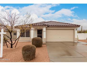 Charming single-story home with a tile roof, neutral stucco, and a two-car garage, set against a partly cloudy sky at 28617 N 50Th Pl, Cave Creek, AZ 85331