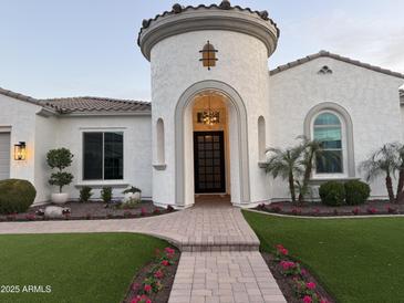 Stunning home featuring a unique turret entrance, beautiful landscaping, and a charming brick walkway at 3675 E Strawberry Dr, Gilbert, AZ 85298