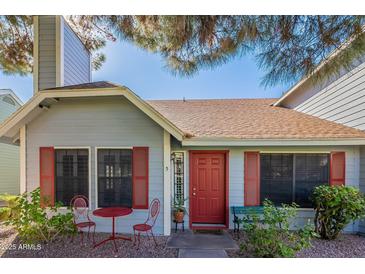 Charming single story home with a cozy front porch, red door and lush landscaping at 4832 E Mineral Rd # 5, Phoenix, AZ 85044